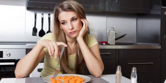 Woman deject over a plate of carrots