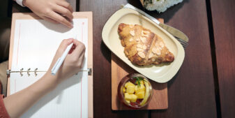 Woman writing in her food diary - emotional eating