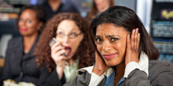Woman covering ears to block out noisy talker