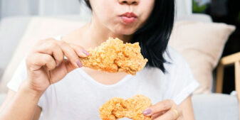 Woman overeating fried chicken
